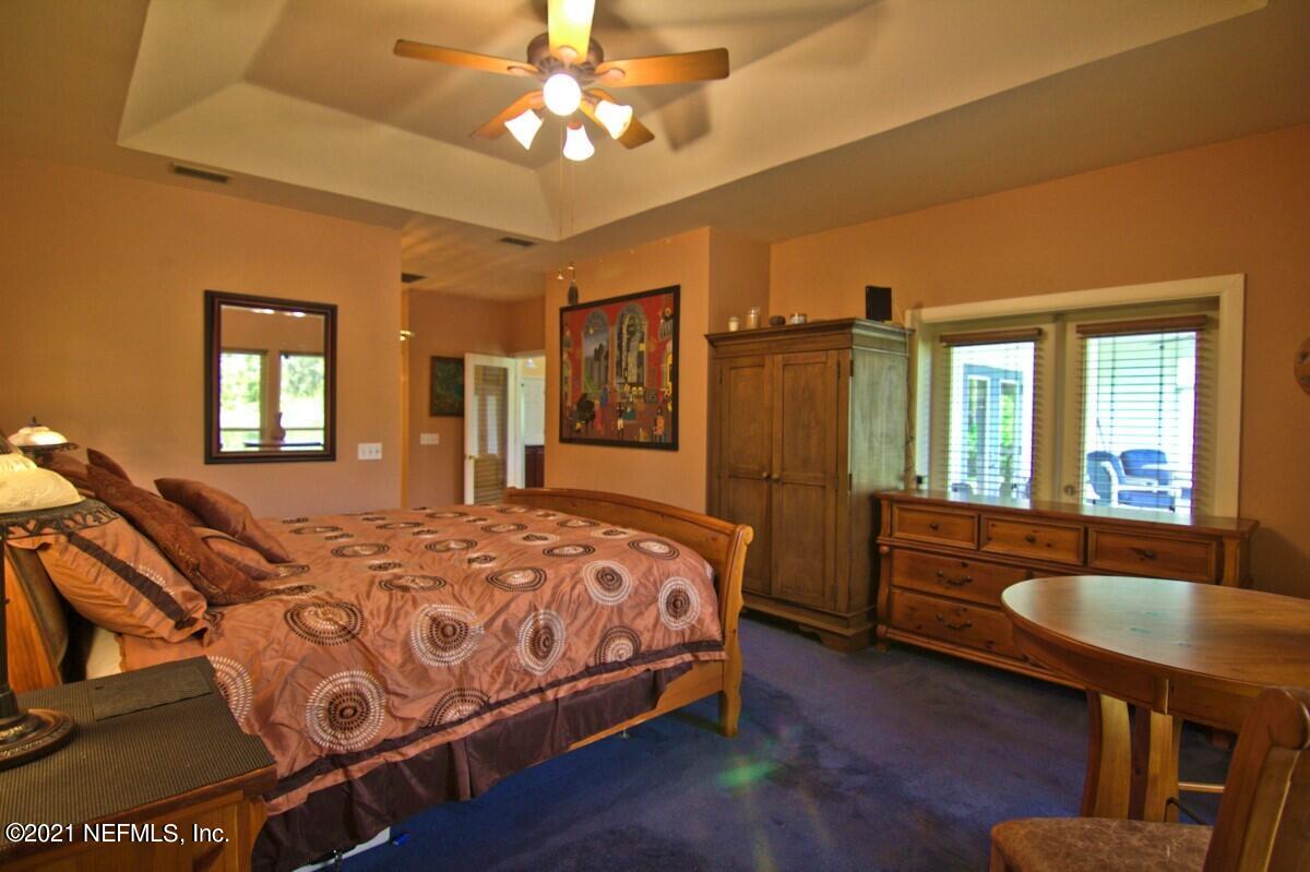 1365 Highway 206 St. Augustine, FL 32086 - Photo 24 of 54 a spacious bedroom with a large bed a chandelier with a dresser