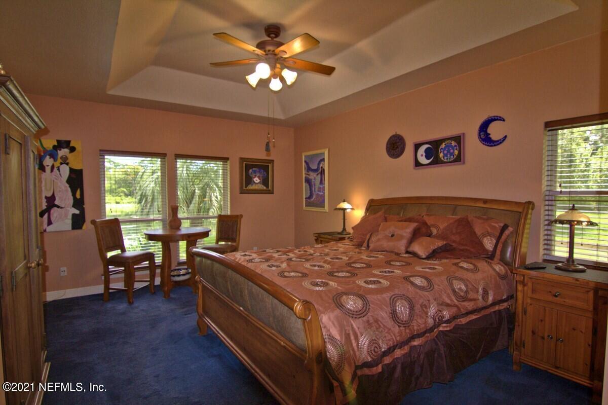 1365 Highway 206 St. Augustine, FL 32086 - Photo 25 of 54 a bedroom with a bed and a chandelier