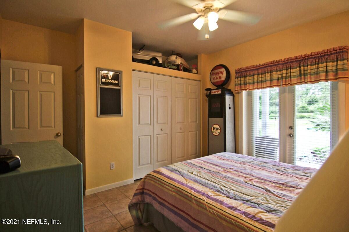 1365 Highway 206 St. Augustine, FL 32086 - Photo 32 of 54 a bedroom with a bed and a chandelier