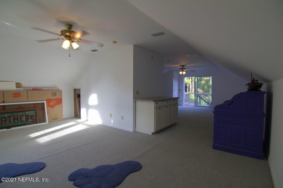 1365 Highway 206 St. Augustine, FL 32086 - Photo 39 of 54 a living room with furniture a chandelier and a fireplace