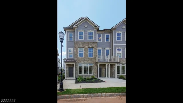 a front view of a house with a garden and trees
