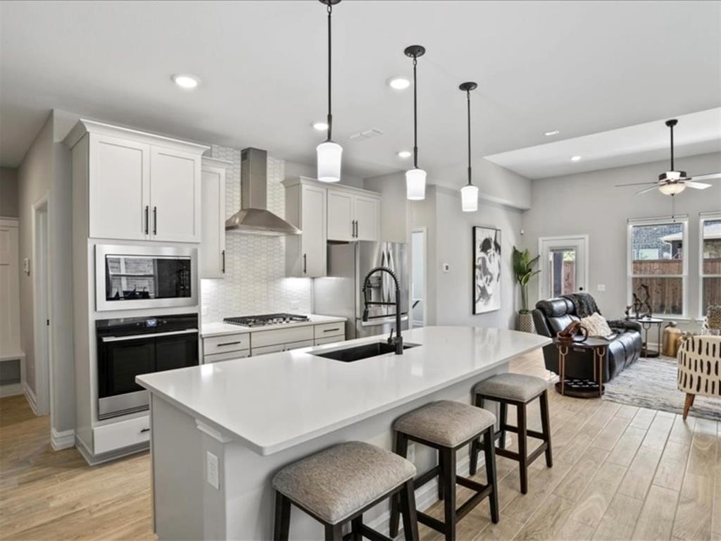 4828 Nicola Road Dallas, TX 75228 - Photo 12 of 38 a kitchen with stainless steel appliances kitchen island granite countertop a table chairs and a refrigerator