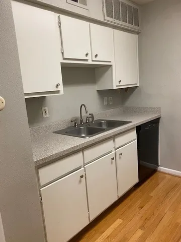 a kitchen with stainless steel appliances granite countertop a sink and a white cabinets
