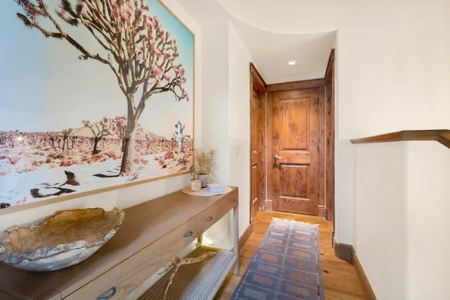 a view of a hallway with wooden floor and windows