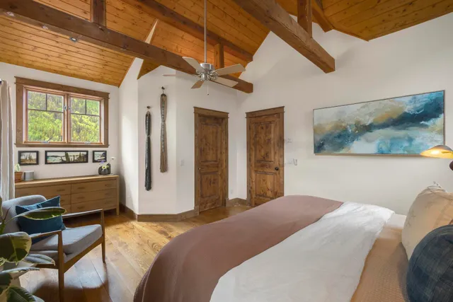 a bedroom with a bed next to a window with a flat screen tv