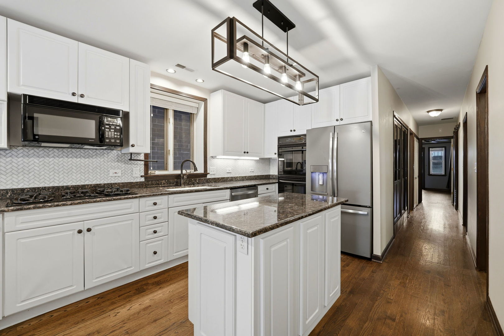 619 North Racine Avenue, Unit 1 Chicago, IL 60642 - Photo 16 of 36 a kitchen with stainless steel appliances granite countertop a refrigerator a stove and a sink with wooden floor