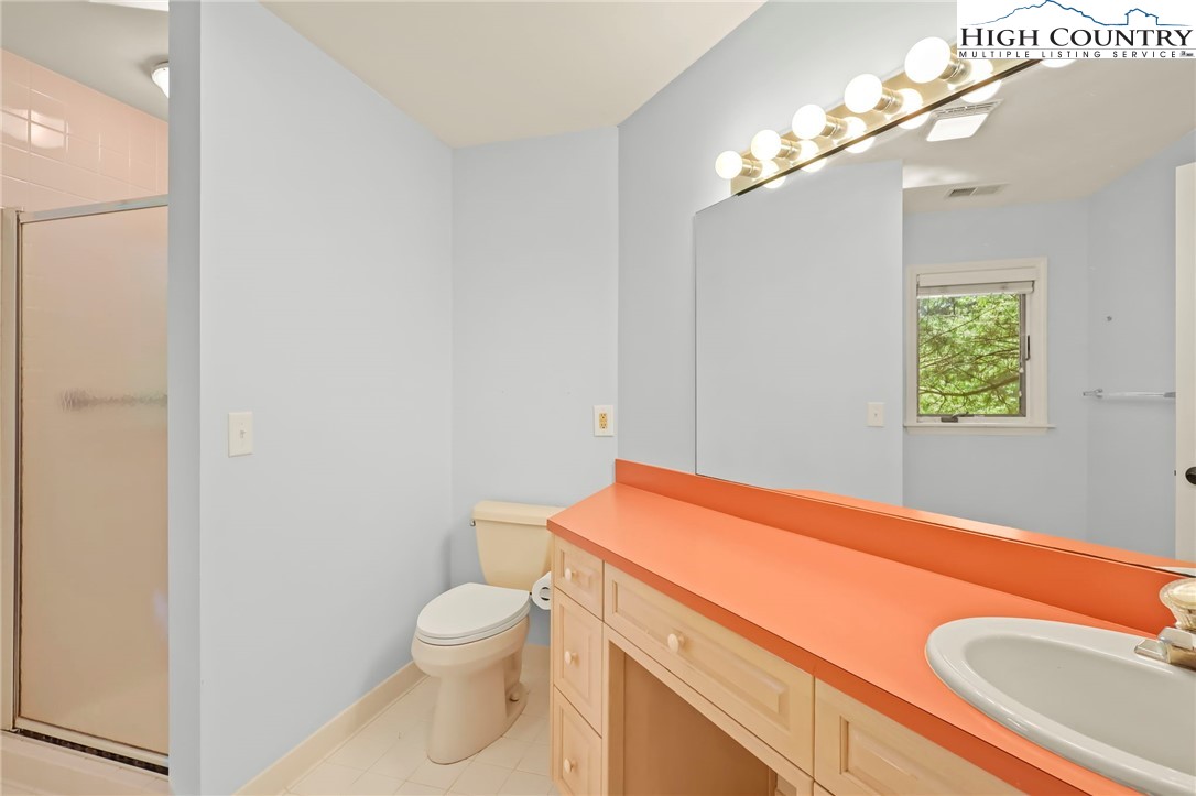 151 Deer Valley Drive, Unit 225 Boone, NC 28607 - Photo 16 of 31 a bathroom with a toilet a sink and mirror