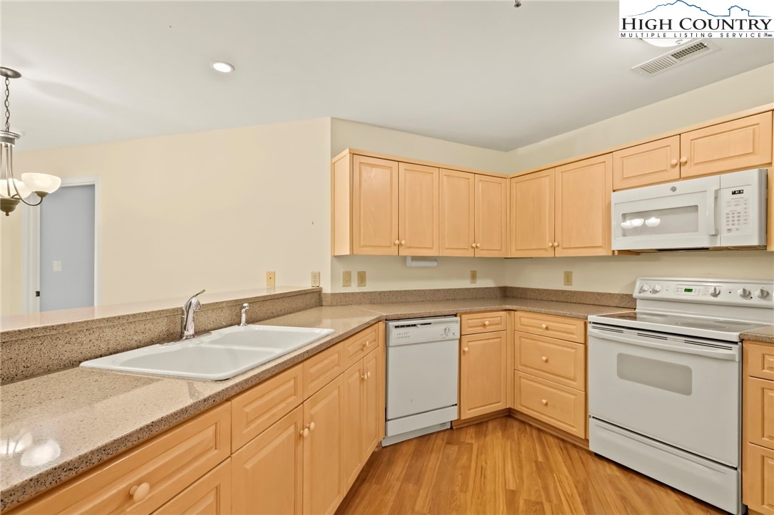 151 Deer Valley Drive, Unit 225 Boone, NC 28607 - Photo 20 of 31 a kitchen with granite countertop white cabinets sink and white appliances