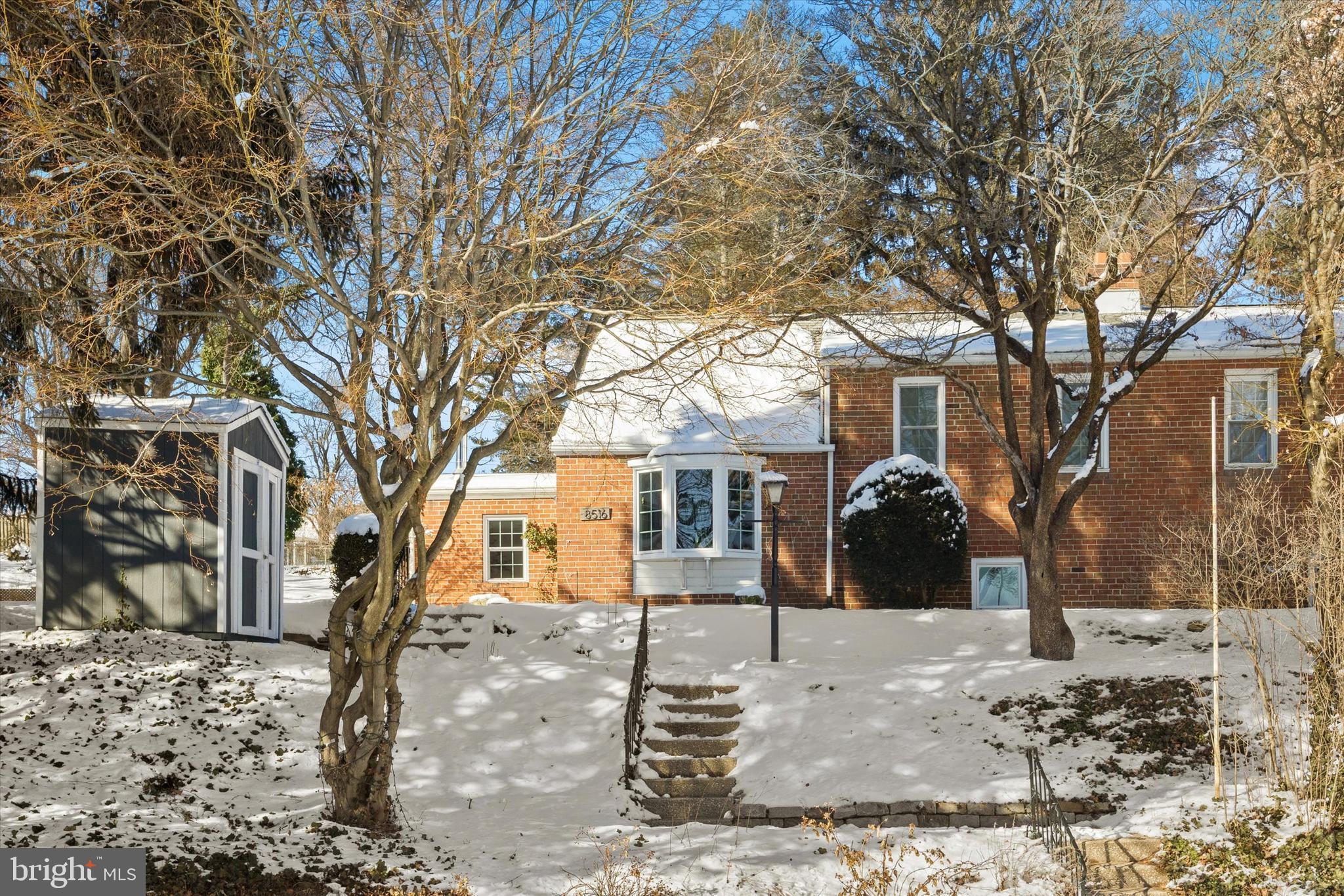 a front view of a house with a yard covered in snow