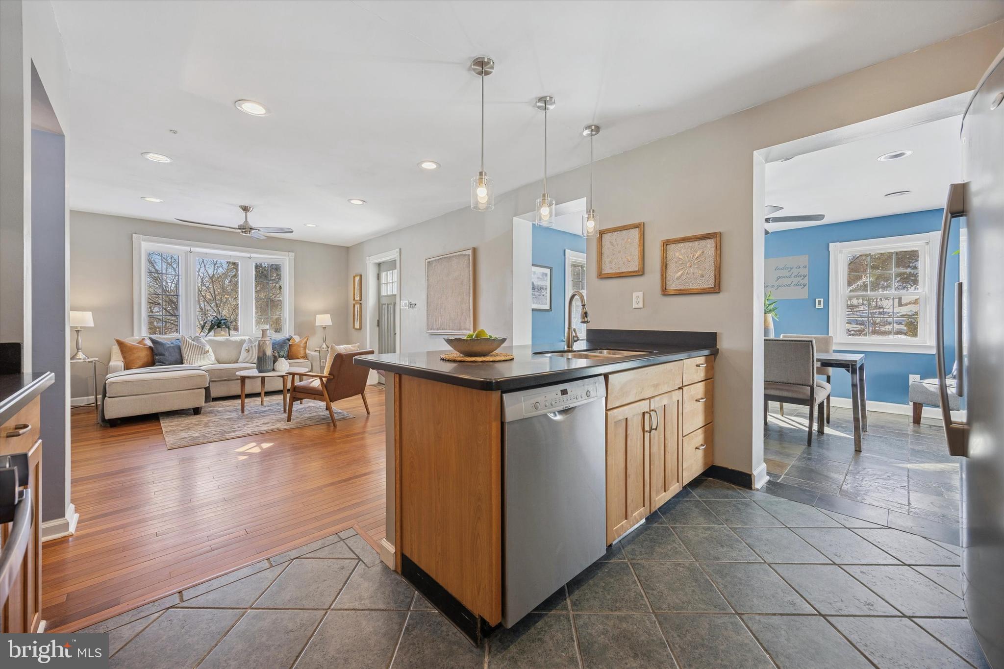 8516 Chippewa Road Philadelphia, PA 19128 - Photo 4 of 20 a kitchen with kitchen island granite countertop lots of white cabinets a sink a stove a dining table and chairs