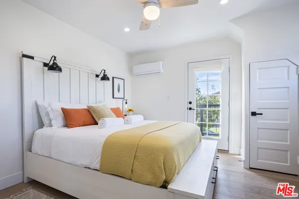 a bedroom with a bed and wooden floor