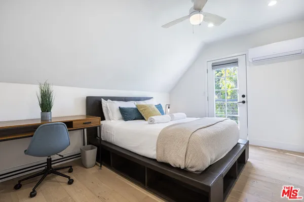 a bedroom with a bed desk and chair