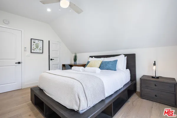 a bedroom with a bed and wooden floor