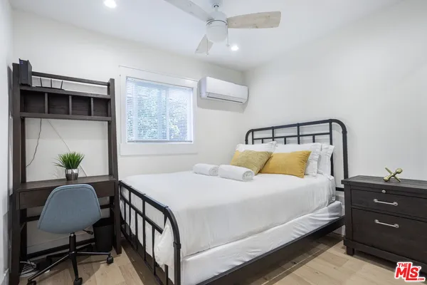 a bedroom with a bed table closet and a window