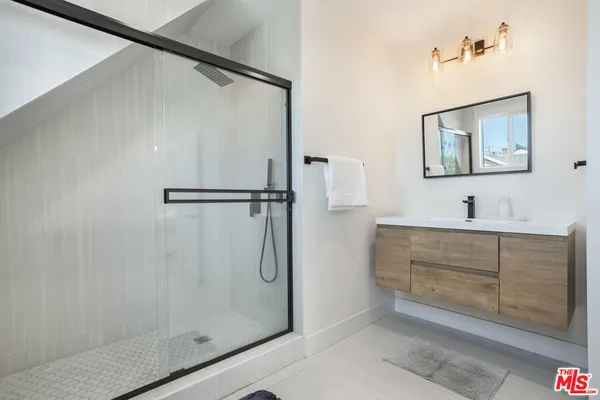 a bathroom with a shower sink and mirror