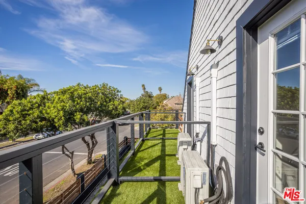 a view of balcony with floor to ceiling windows and wooden fence