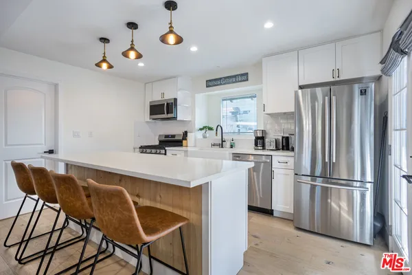 a kitchen with stainless steel appliances granite countertop a refrigerator and a stove top oven