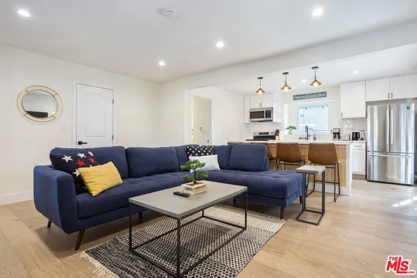 a living room with furniture and kitchen view