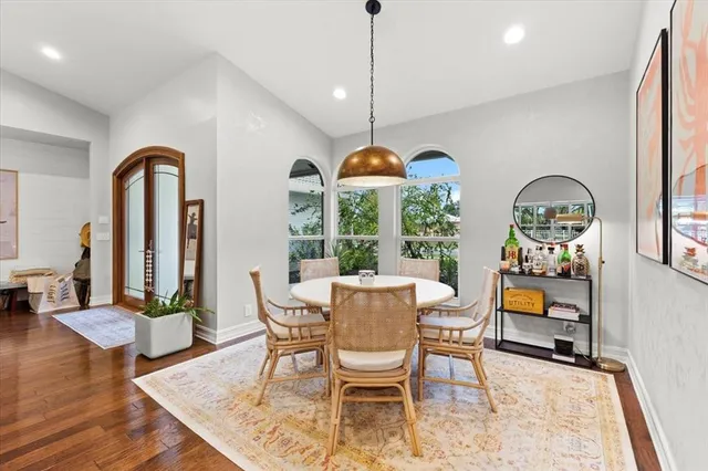 a dining room with wooden floor a chandelier a wooden table and chairs