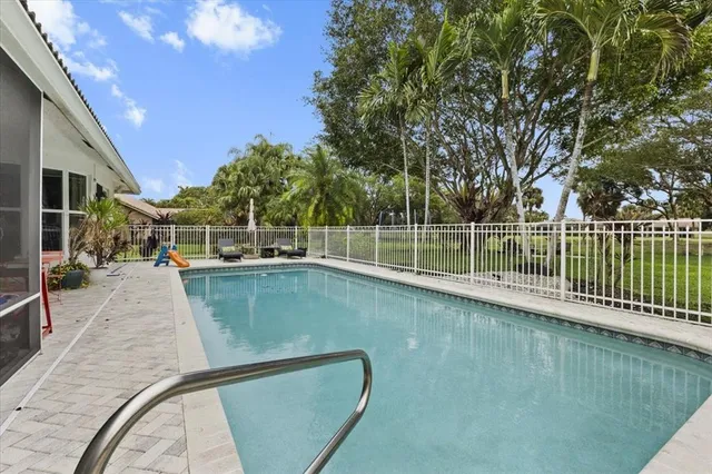a view of a patio with table and chairs potted plants and a large tree