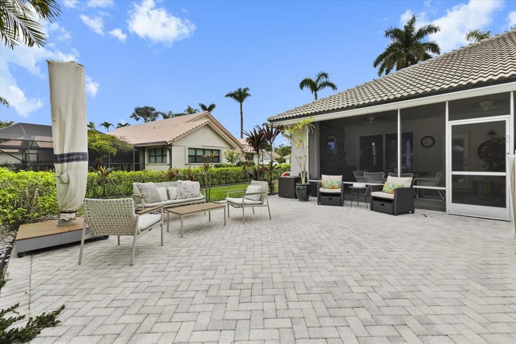 10349 Camelback Lane Boca Raton, FL 33498 - Photo 34 of 38 a view of a patio with table and chairs potted plants and a large tree