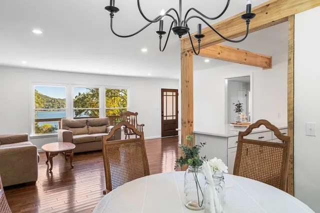 a living room with furniture a chandelier and wooden floor