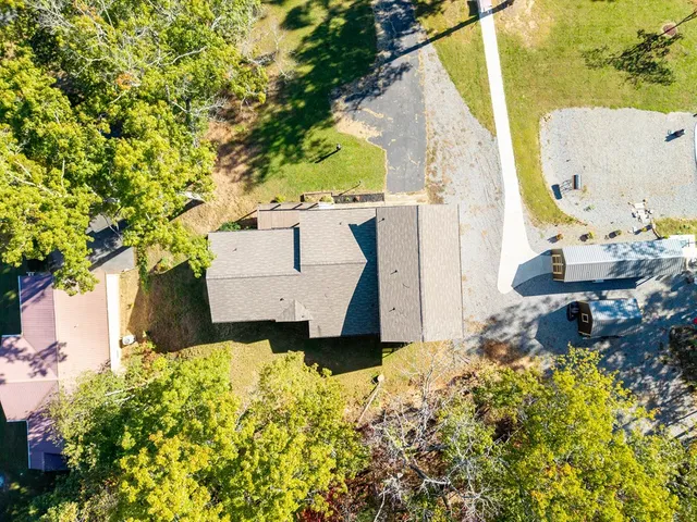 an aerial view of a house with a yard and wooden fence
