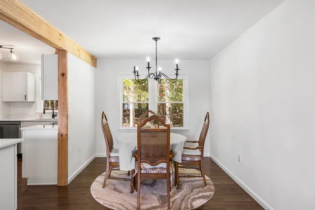 a dining room with furniture a chandelier and wooden floor