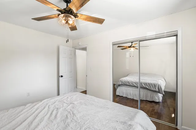 a bedroom with a bed mirror and window