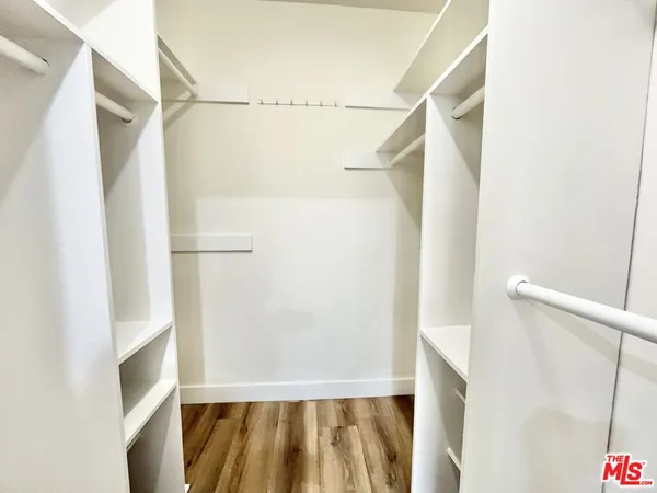 a view of walk in closet with clothes and shower