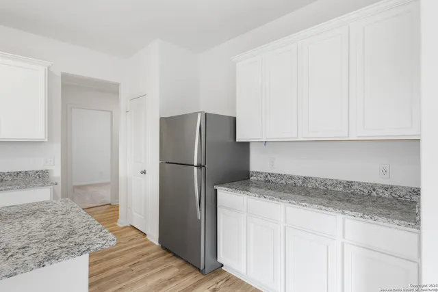 a kitchen with stainless steel appliances granite countertop a refrigerator and a sink