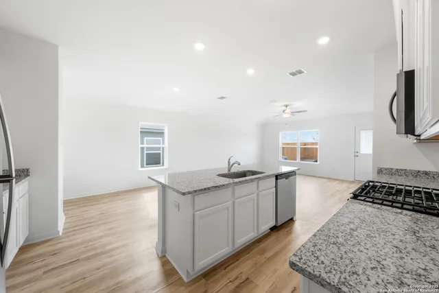 a kitchen with granite countertop a sink and a stove top oven