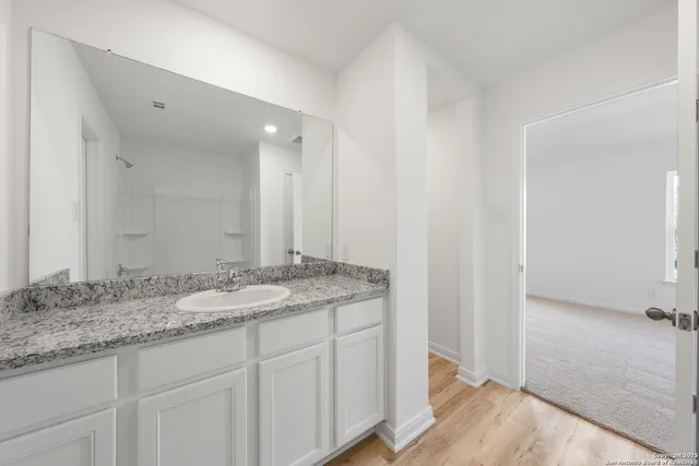 a bathroom with a granite countertop sink and a mirror