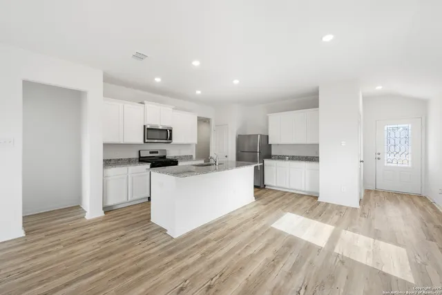 a kitchen with white cabinets and stainless steel appliances