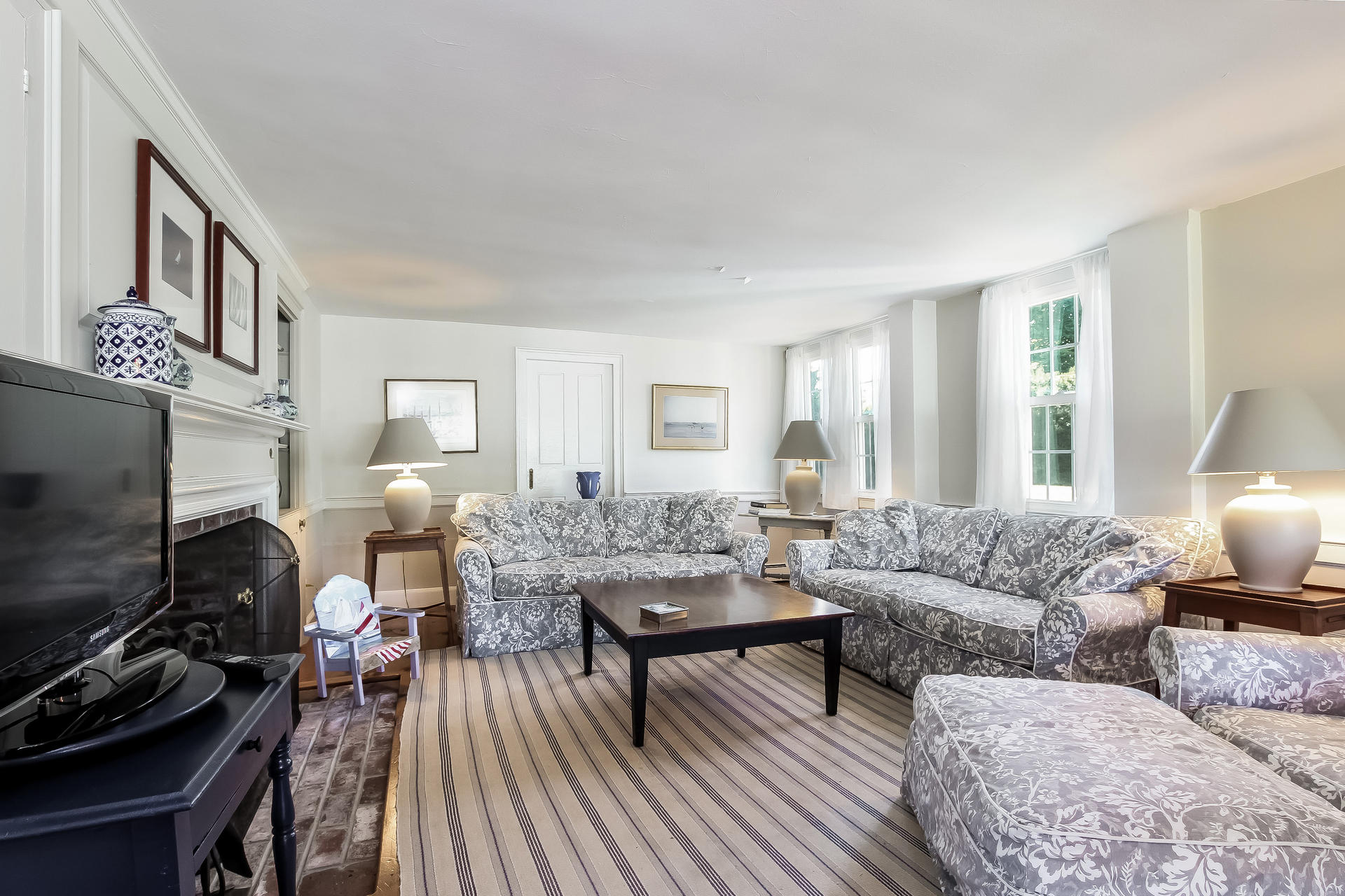 489 Stage Harbor Road Chatham, MA 02633 - Photo 7 of 34 a living room with furniture a fireplace and a flat screen tv