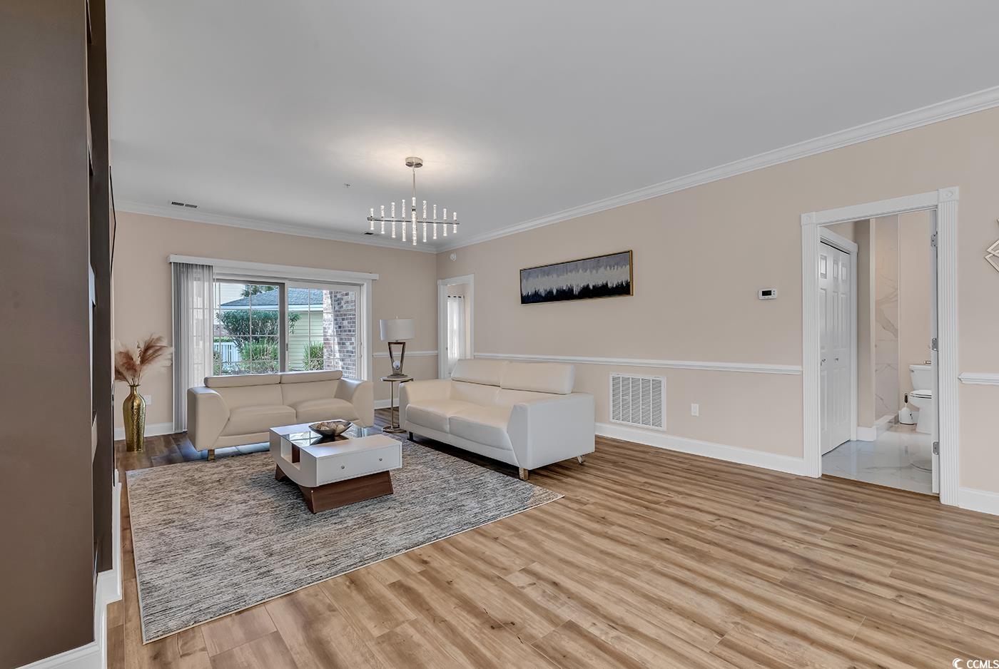 4821 Luster Leaf Circle, Unit 101 Myrtle Beach, SC 29577 - Photo 11 of 40 Living room with light wood-type flooring, crown m