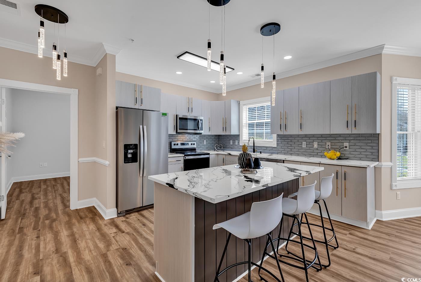 4821 Luster Leaf Circle, Unit 101 Myrtle Beach, SC 29577 - Photo 5 of 40 Kitchen featuring a center island, pendant lightin
