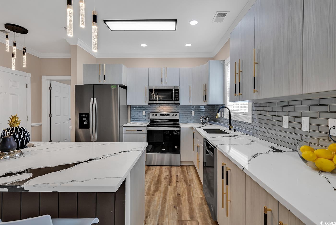 4821 Luster Leaf Circle, Unit 101 Myrtle Beach, SC 29577 - Photo 6 of 40 Kitchen with sink, decorative light fixtures, appl