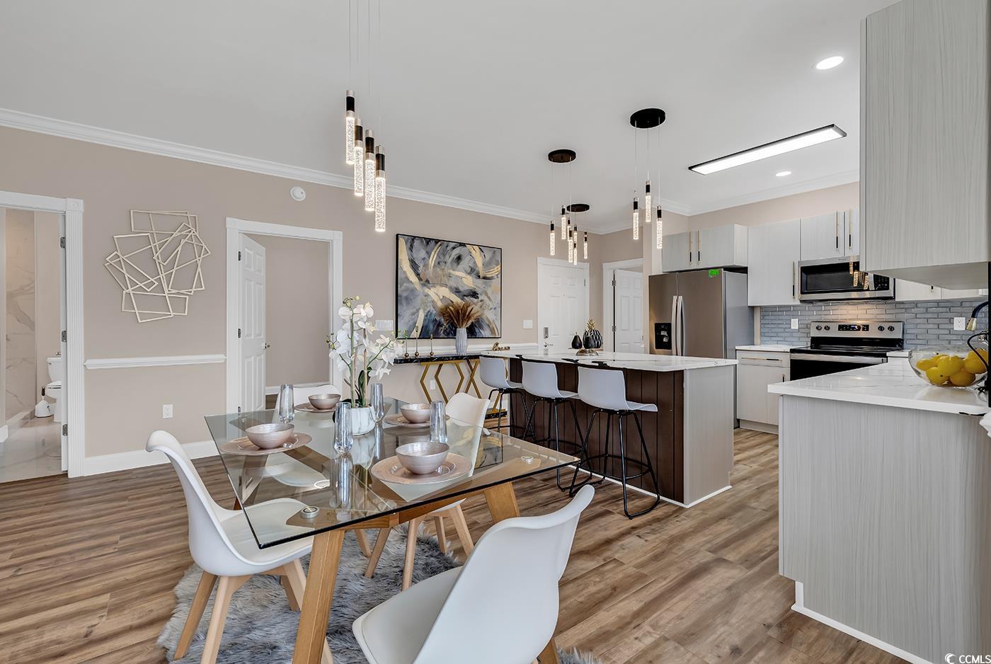 4821 Luster Leaf Circle, Unit 101 Myrtle Beach, SC 29577 - Photo 9 of 40 Dining space with ornamental molding and light har