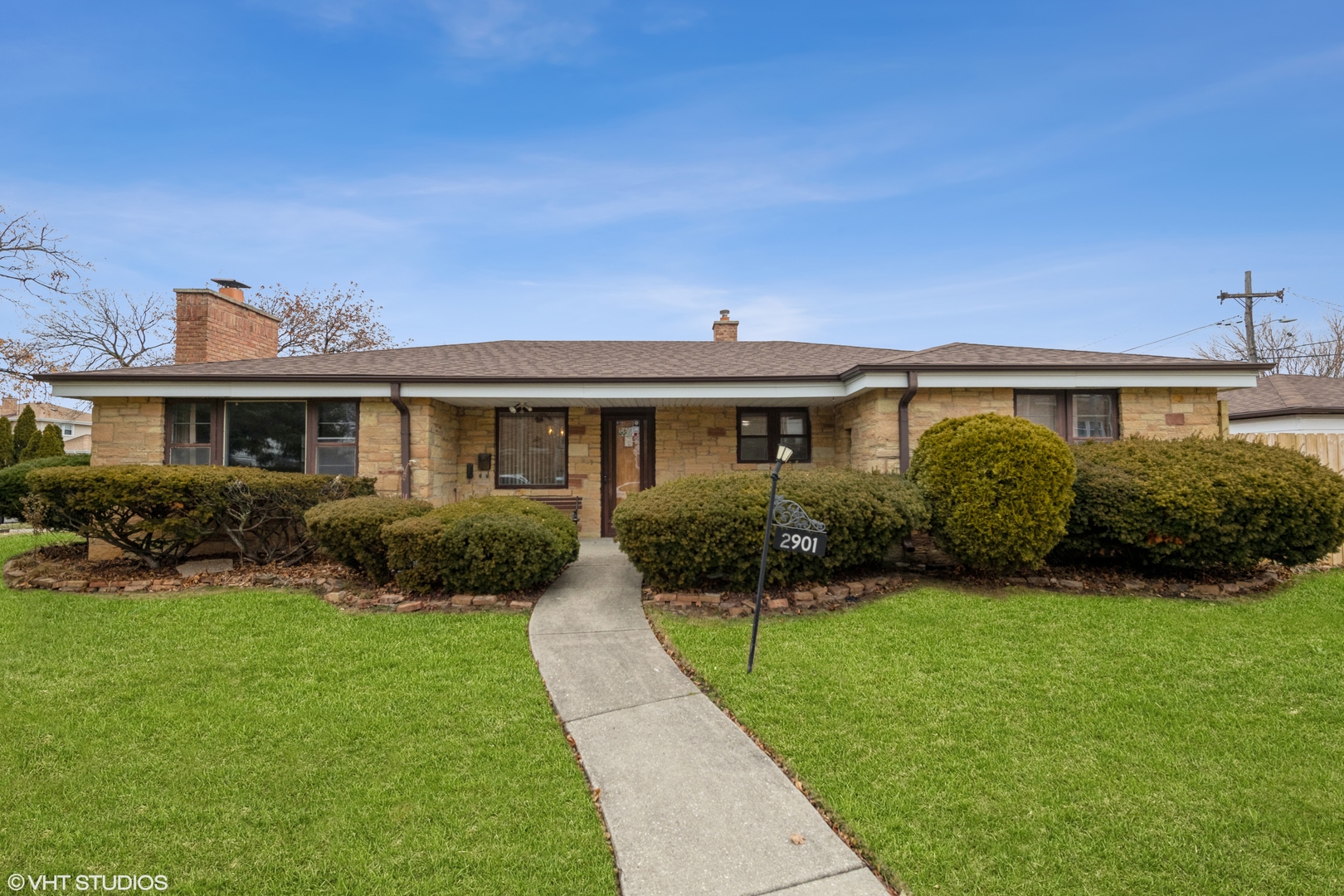 a front view of a house with a yard and potted plants