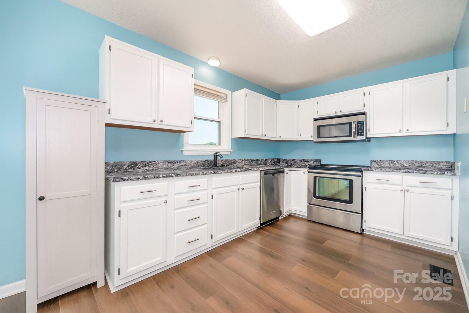 245 Castle Keep Road Salisbury, NC 28146 - Photo 9 of 26 a kitchen with granite countertop white cabinets and white appliances