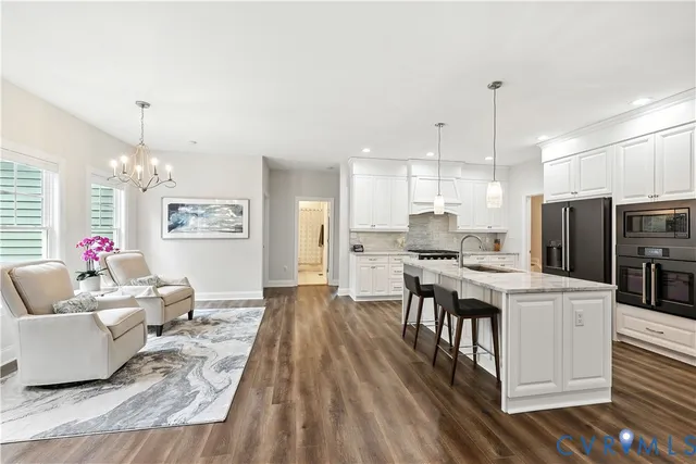 a living room with stainless steel appliances kitchen island granite countertop furniture and a kitchen view