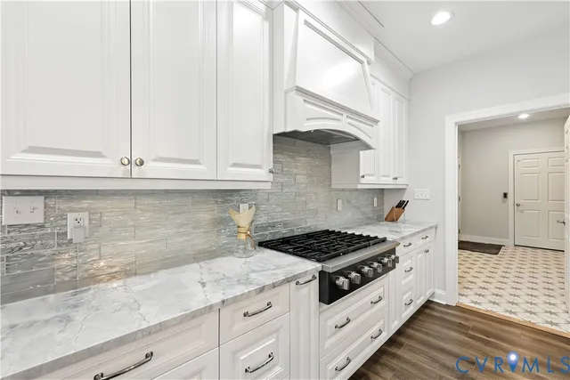 a kitchen with granite countertop white cabinets and white appliances