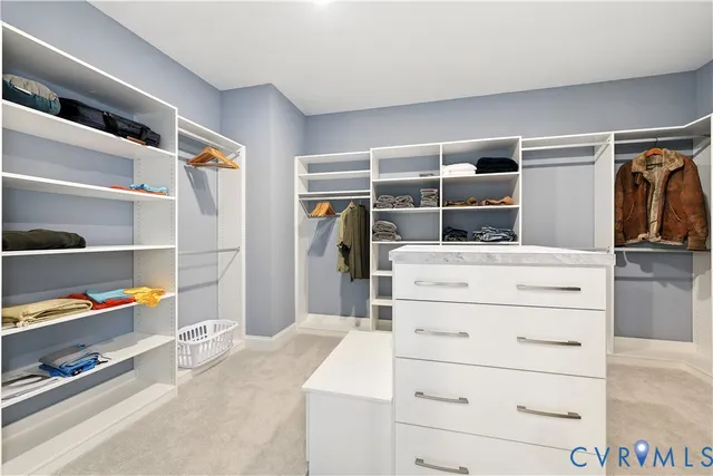 a view of walk in closet with clothes and shoes
