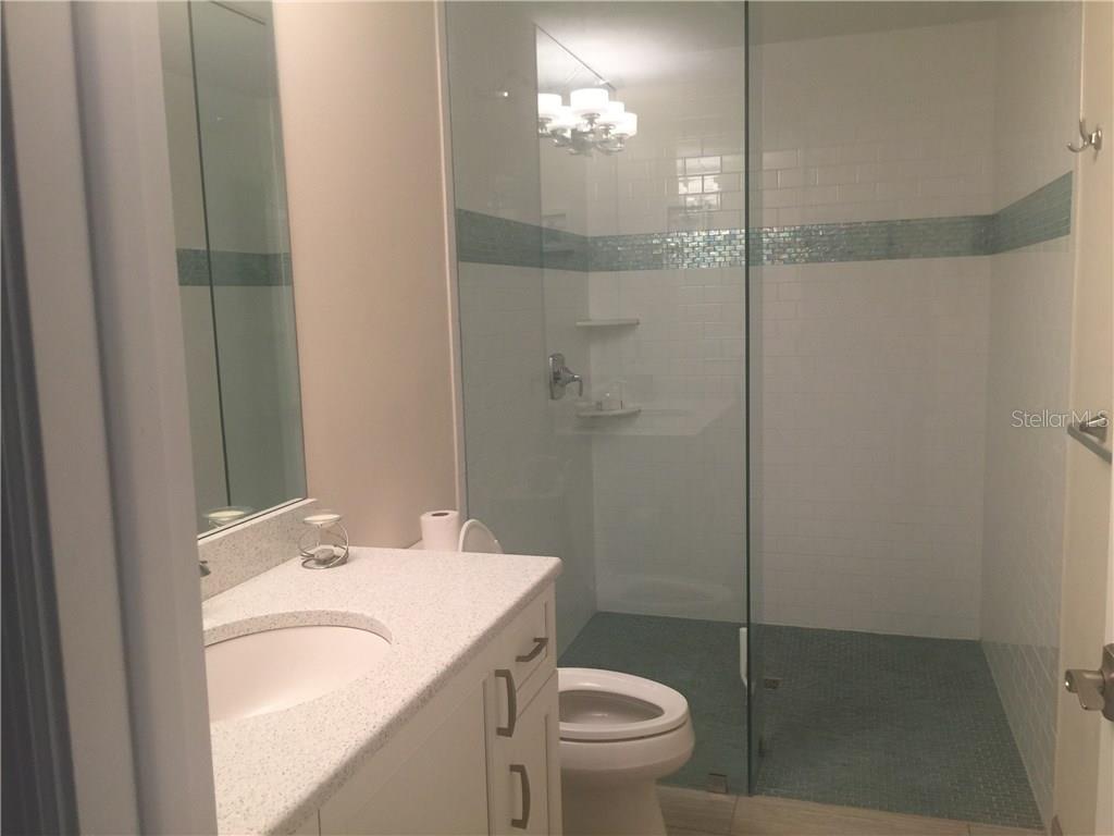 5519 Azure Way Sarasota, FL 34242 - Photo 11 of 25 a bathroom with a granite countertop sink toilet and shower