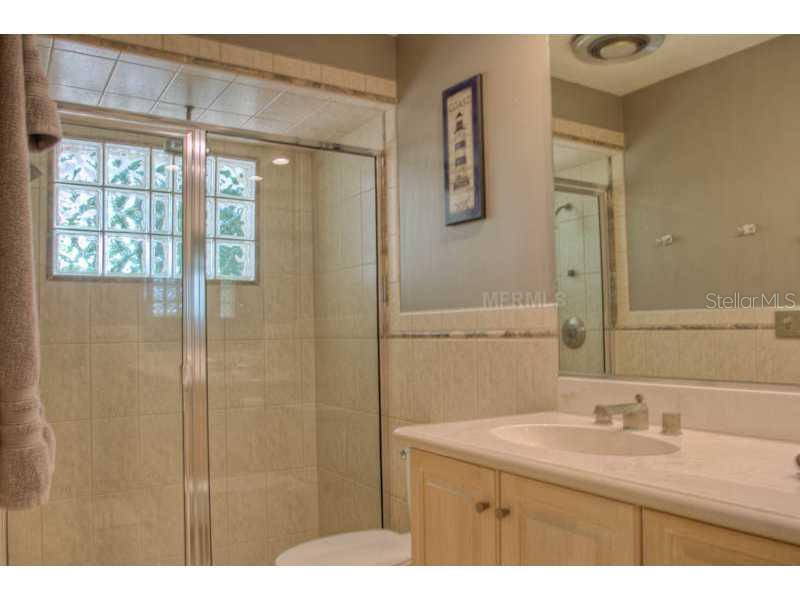 5519 Azure Way Sarasota, FL 34242 - Photo 20 of 25 a bathroom with a granite countertop sink a mirror and a shower
