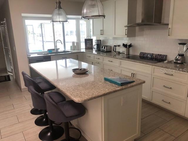 5519 Azure Way Sarasota, FL 34242 - Photo 2 of 25 a kitchen with granite countertop a sink a window and stainless steel appliances