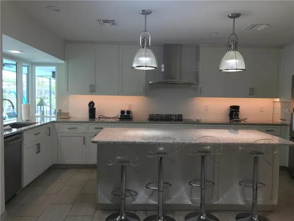 a kitchen with counter top space and wooden floor