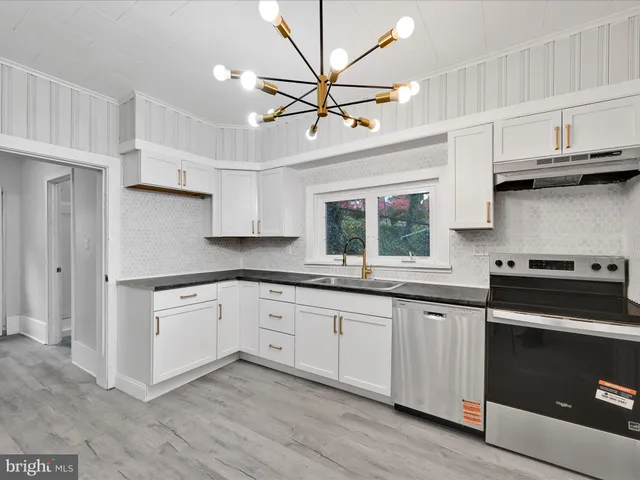 a kitchen with stainless steel appliances granite countertop a sink a stove and a refrigerator