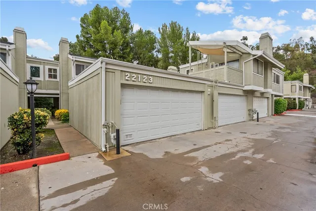 a view of a white house with a large space and large windows